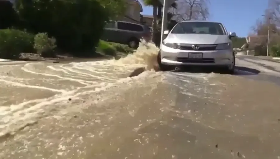 Car stuck on a road flooded by a burst water pipe – what to do when a pipe bursts